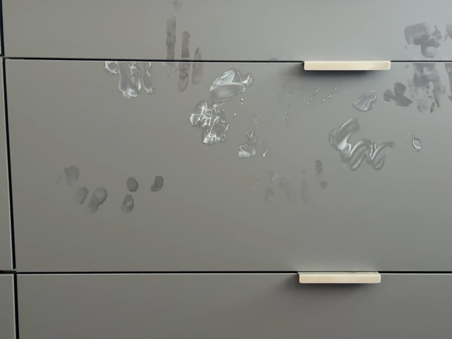 Matte Küchenfront mit Fingerabdrücken und Schlieren im Gegenlicht